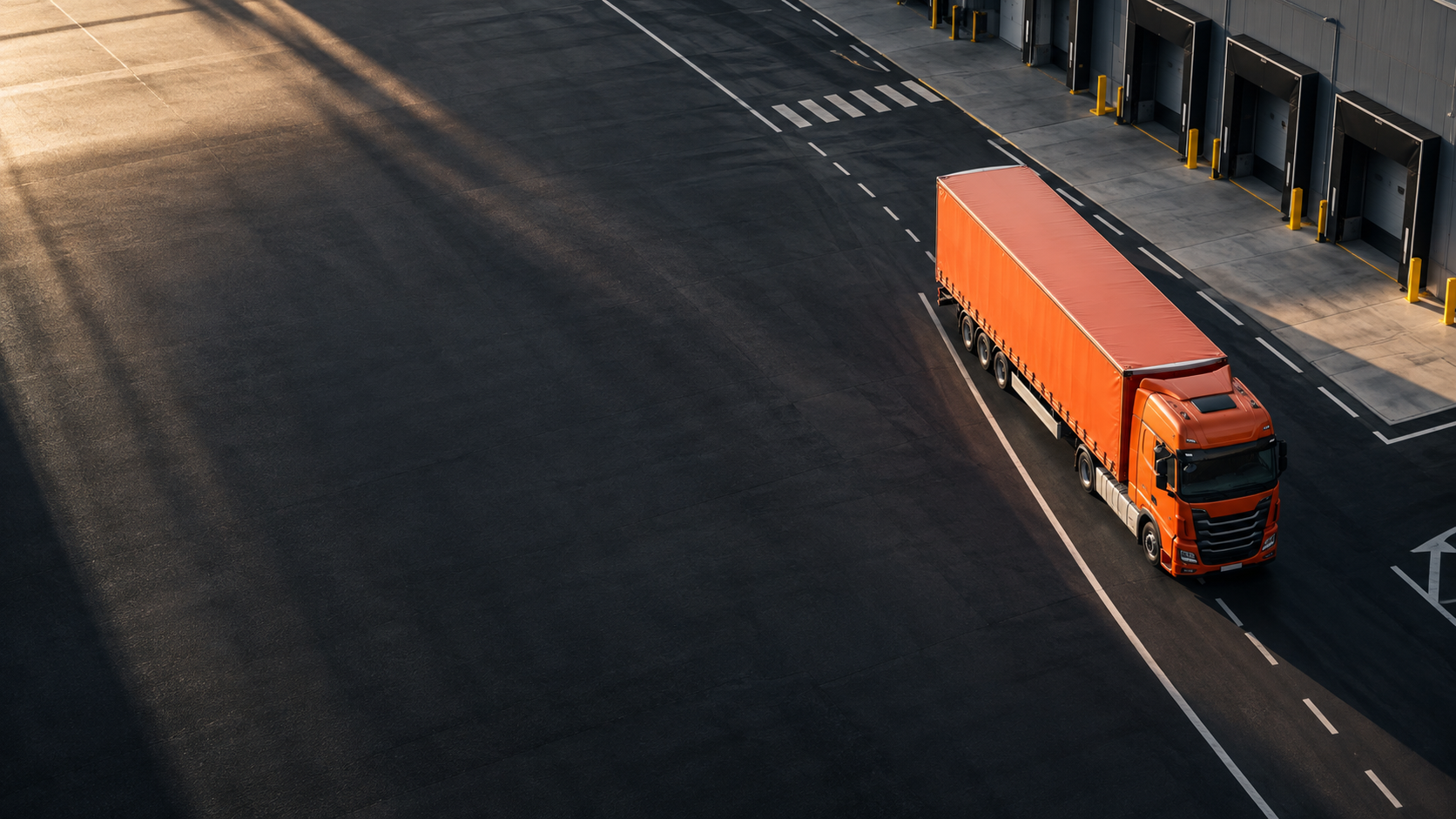 Illustrative orange lorry in a logistics yard